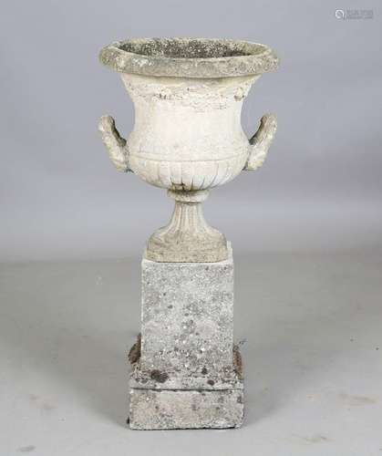 A 20th century cast composition stone garden urn of twin-han...