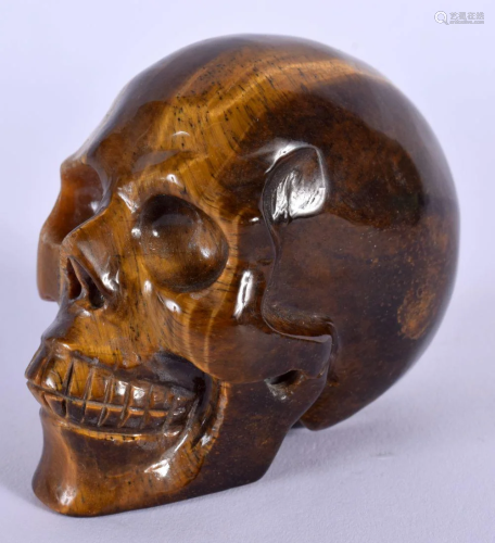 A CHINESE CARVED TIGERS EYE SKULL 20th Century. 7 cm x 5 cm.