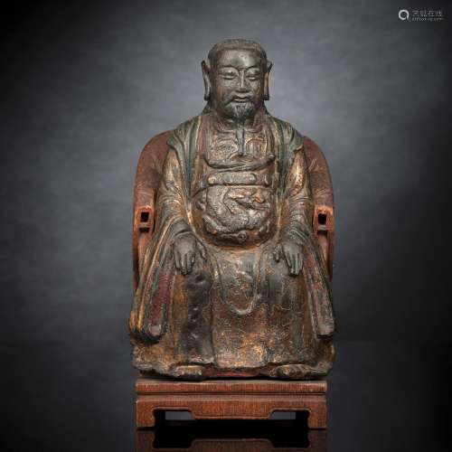 A GILT-LACQUERED BRONZE MODEL OF GUANDI SEATED ON A CARVED W...