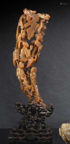 A WELL CARVED HORN WITH FIGURAL DECORATION ON A CARVED WOOD ...