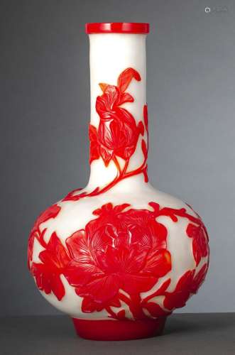 A WHITE GLASS BOTTLE VASE WITH PEONIES IN RED OVERLAY