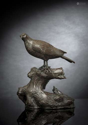 A WELL-CAST TWO-PART BRONZE MODEL OF A BIRD OF PREY SEATED O...