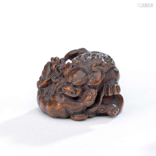 A FINE BOXWOOD NETSUKE OF A GROUP OF THREE PLAYFUL SHISHI