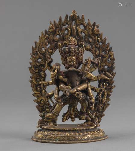 A GILT-BRONZE FIGURE OF A TANTRIC DEITY ON AN INSCRIBED BASE