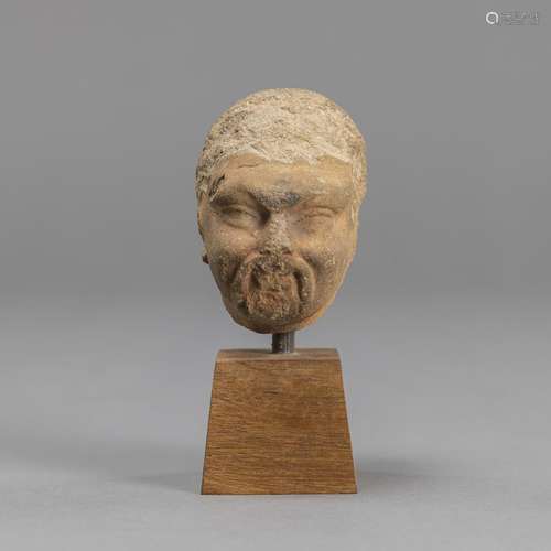 A SANDSTONE HEAD OF A SCHOLAR