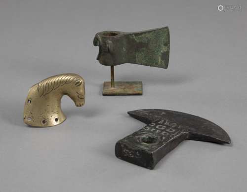 TWO BRONZE HATCHETS AND A HORSEHEAD FITTING