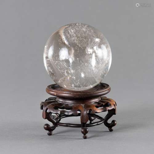 A CRYSTAL SPHERE ON A WOOD STAND