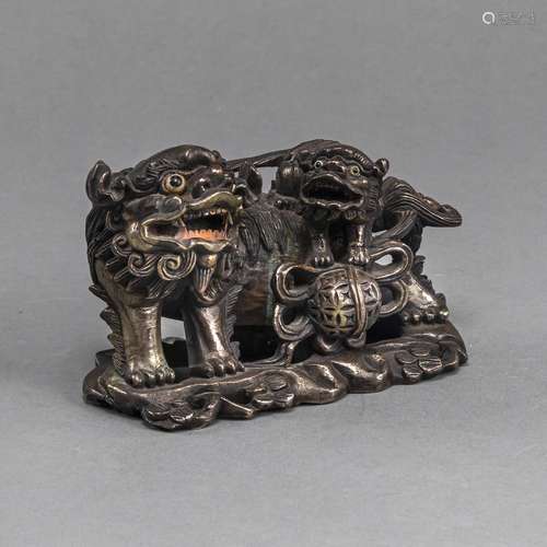 A PARTIALLY SILVERED COPPER ON WOOD CARVING OF A FO LION WIT...