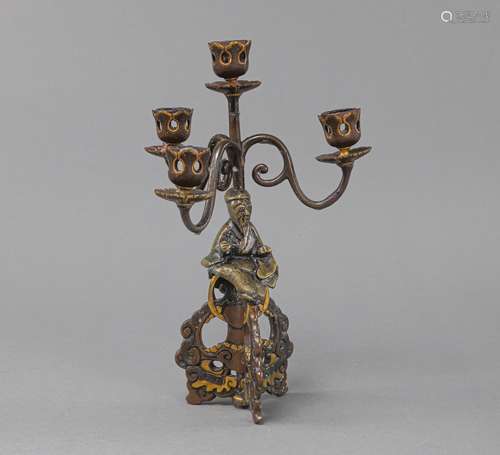 A BRONZE SCHOLAR CANDLESTICK