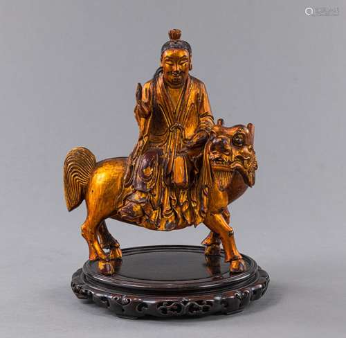 A LACQUER-GILT WOOD FIGURE OF A DAOIST ON A MYTHICAL BEAST