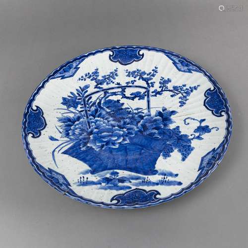 A LARGE UNDERGLAZE BLUE PLATE DECORATED WITH A FLOWER BASKET