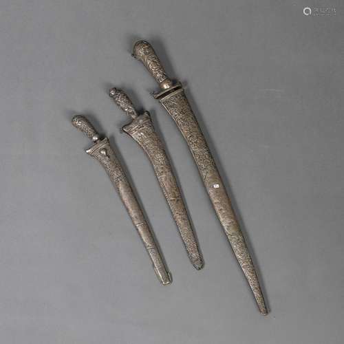 THREE SHORT SWORDS WITH WHITE METAL SCABBARDS WITH FLORAL DE...