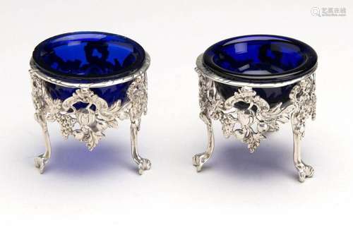 A pair of silver salt cellars with blue glass liners