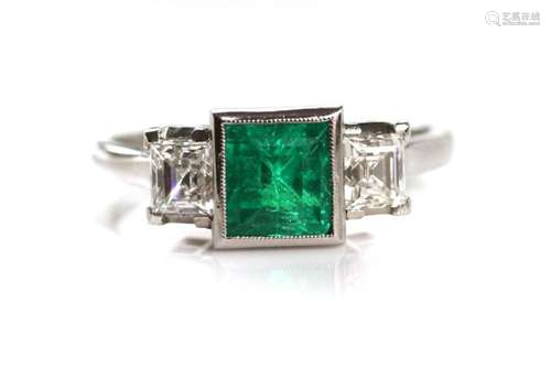 A platinum emerald and diamond three stone ring