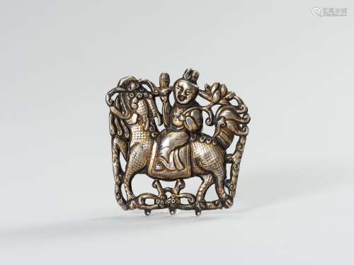 A PARCEL GILT SILVER REPOUSSE ORNAMENT OF GUANYIN ON A BUDDH...