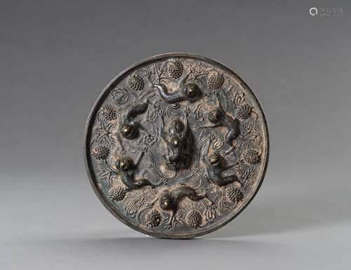 A TANG-STYLE BRONZE 'LIONS AND GRAPEVINES' MIRROR