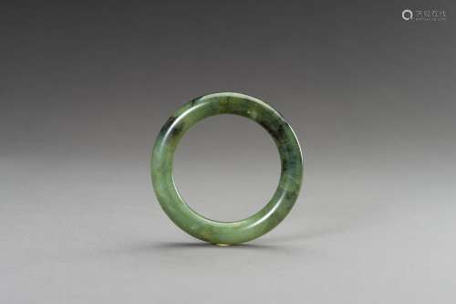 A MOTTLED SPINACH GREEN JADE BANGLE, REPUBLIC PERIOD OR LATE...