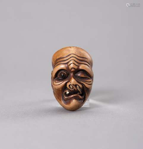 A VEGETABLE IVORY MASK OF AN OLD MAN