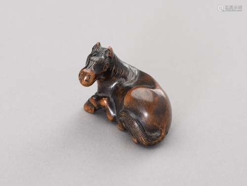 A WOOD NETSUKE OF A RECUMBENT HORSE