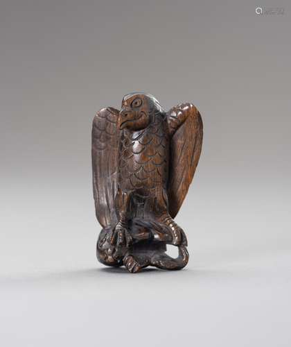 A WOOD NETSUKE OF AN EAGLE SNATCHING A RABBIT