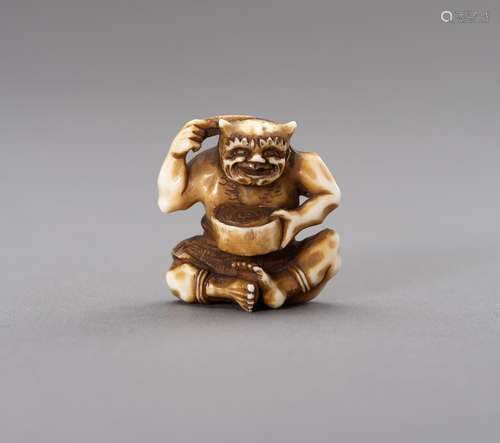 Ɏ AN IVORY NETSUKE OF AN ONI COMBING HIS HAIR