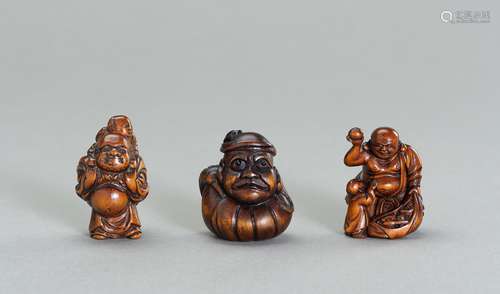 A GROUP OF THREE WOOD NETSUKE OF HOTEI AND DARUMA