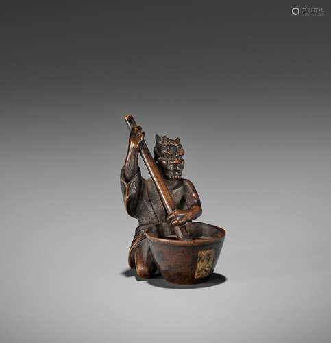 SHOKO: A WOOD NETSUKE OF AN ONI STIRRING MISO