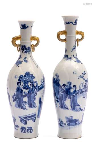 Two tall slender blue and white vases with figures