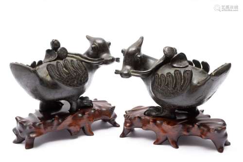 A pair of bronze ducks with lotus on wooden bases