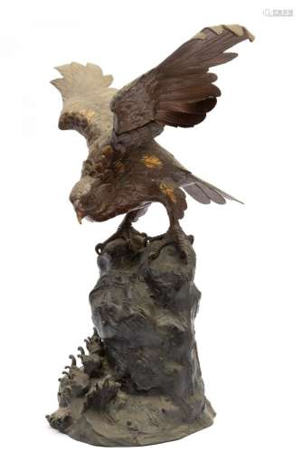 A Japanese metal figure of an eagle on a rock