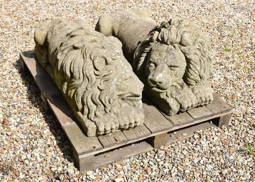 A PAIR OF STONE COMPOSITION RECUMBENT LIONS LOOSELY IN THE M...