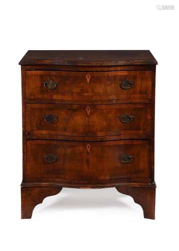 A WALNUT AND CROSSBANDED SERPENTINE FRONTED CHEST OF DRAWERS...