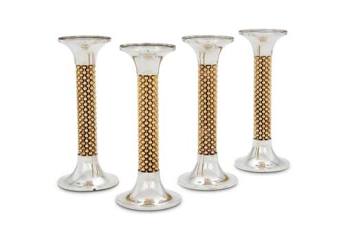 A SET OF FOUR SILVER AND SILVER GILT CANDLESTICKS