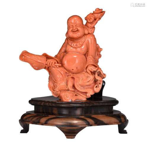 A Chinese red coral figure of a prosperous smiling Budai, la...