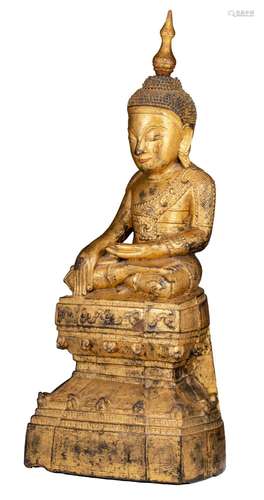 A Burmese gilt wooden Buddha, seated on a two-tier base, 19t...