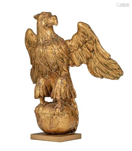 A gilt limewood sculpture of an eagle on an orb, 18thC, H 39...