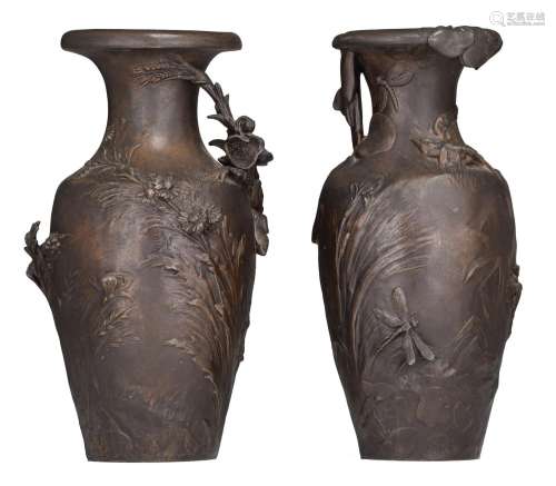 A pair of patinated spelter vases with flower relief decorat...