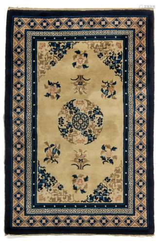 A Chinese woollen carpet, decorated with a central medallion...