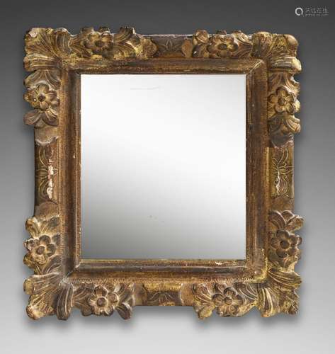 Miroir en bois sculpté et doré à décor de feuilles et fleure...