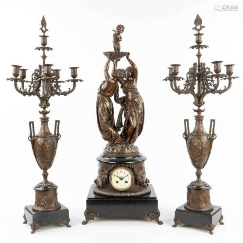 A three-piece garniture clock and candelabra, made of spelte...
