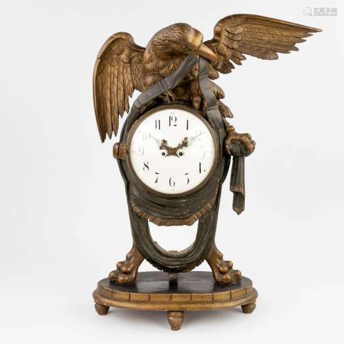 An antique wood sculptured mantle clock with an eagle figuri...