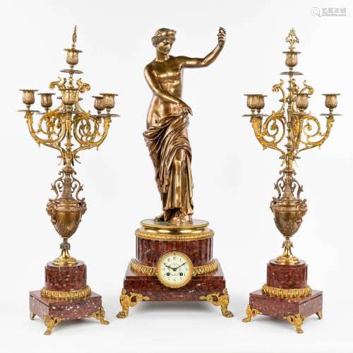 A three-piece mantle garniture clock and candelabra, polishe...