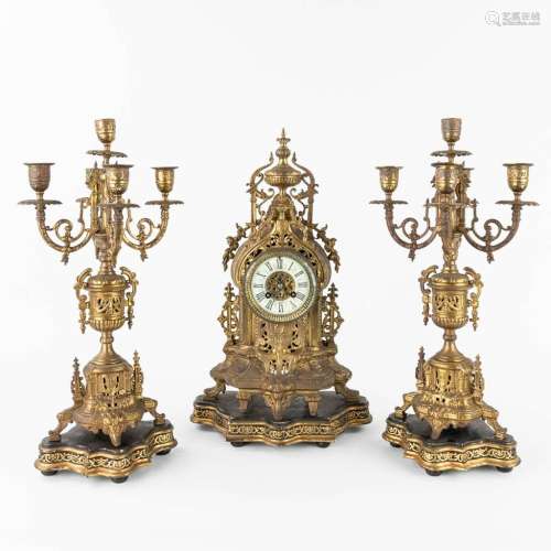 A three-piece mantle garniture clock and candelabra, made of...