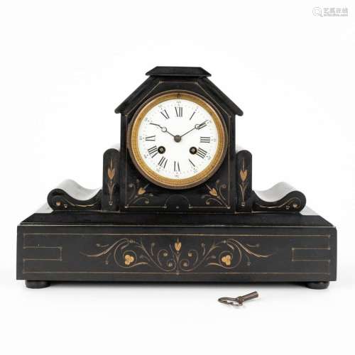 A mantle clock made of black marble and finished with yellow...
