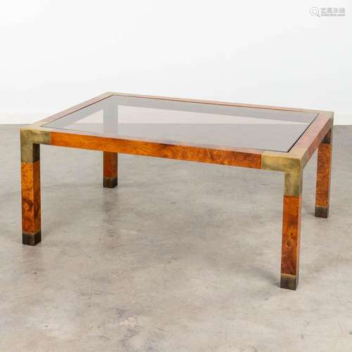 A mid-century coffee table with burl wood and brass. In the ...