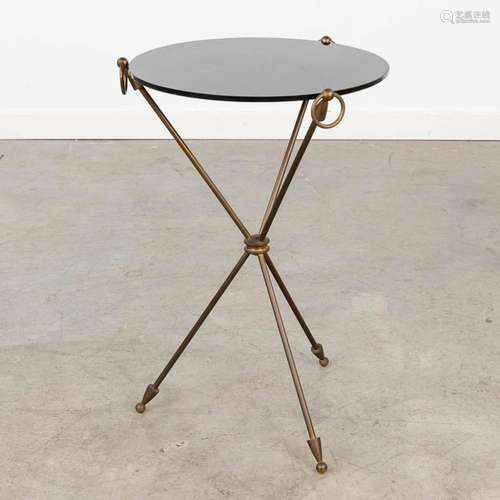 A vintage side table with arrows and a black glass top. Circ...