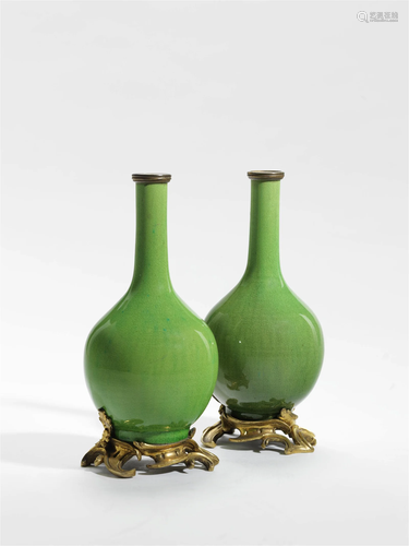 AN ORMOLU MOUNTED PAIR OF APPLE GREEN PORCELAIN VASES THE PO...