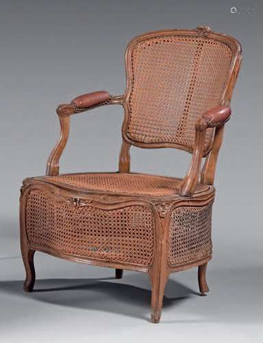 Fauteuil de commodité en hêtre mouluré et sculpté à décor de...