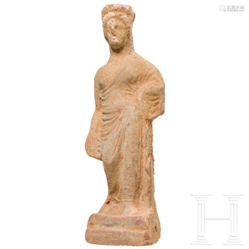 A Greek terracotta of a standing woman with polos and phiale...
