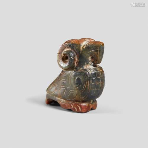 AN ARCHAISTIC SHANG-STYLE GREEN AND BROWN JADE FIGURE OF A H...